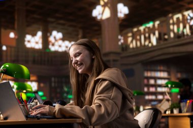 Kendine güvenen öğrenci, üniversite kütüphanesinden bilgi ve celp topluyor. Büyük veritabanı aracılığıyla, lisans diploması üzerinde çalışıyor. Sertifika için çalışan zeki bir kız..