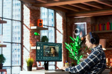 Ofisteki kişi gerçekçi videolar üreten gelişmiş yapay zeka yazılımını kullanıyor. Adam, sosyal medya içeriği oluşturmak için açıklayıcı metinden klipler üreten yapay zeka asistanı kullanıyor