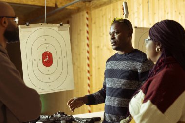 Neşeli bir grup arkadaş atış poligonunda eğleniyor, silah kullanmayı bitirdikten sonra sohbetin tadını çıkarıyorlar. Takım oluşturmada neşeli meslektaşlar hedefleri silahla vurduktan sonra mutlu oluyorlar.