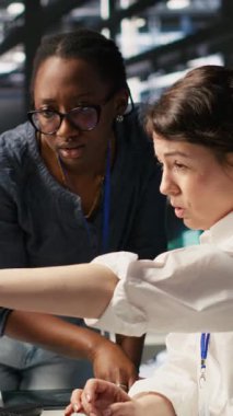 Dikey video veri merkezi teknisyenleri, sunucu donanımı ayarlayan yapay zeka işleme operasyonları. İş arkadaşları sunucu dizilerinin eğitim verilerinin altyapısını denetlemektedirler