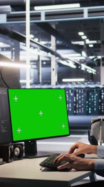 Server teknolojisini güncellemek için veri merkezinde yeşil ekran modelleme PC kullanan dikey video mühendisi, yazılım araçları kullanarak ekipmanları yapılandırıyor. Sunucu odası çalışanı krom anahtar PC üzerindeki donanım analizlerini inceliyor