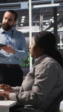 Dikey video Sinirli Veri Merkezi çalışanı iş yerindeki anlaşmazlık sırasında iş arkadaşına kaba bir el hareketi yapıyor. Sunucu merkezindeki kızgın kadın tartışma sırasında iş arkadaşını hiçe sayıyor. Kamera A: