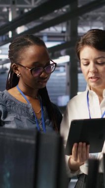 Dikey video veri merkezi takım arkadaşları sunucu raflarında yapay zeka işleme için bakım yapıyorlar. Makine için kullanılan sunucu merkezi donanımlarını yöneten mühendislik ekibi