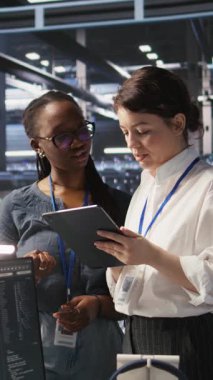 Veri merkezinde çalışan dikey video ekip mühendisleri bakım oturumu sırasında yapay zeka otomasyon araçlarını birleştirirler. Sunucu odası arkadaşları sunucu üzerinden makine öğrenme modellerini yapılandırdılar