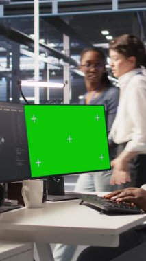 Dikey video veri merkezi denetleme donanımı yeşil ekran model PC kullanarak, bakım görevleri yapıyor. Krom anahtar bilgisayar kullanan, sistem kontrolü yapan, kamera kullanan Afro-Amerikan sunucu işçisi.