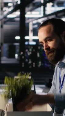 Dikey video veri merkezi mühendisi, AI otomasyon işlemleri tarafından değiştirildikten sonra masa başı eşyalarını paketliyor. Hayal kırıklığına uğramış adam yapay olarak işgücünün yer değiştirmesinden muzdarip.