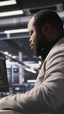 Dikey Veri Merkezi bilgisayar bilimci sunucuları yapay zeka eğitimi ve çıkarım görevleri yerine getiriyorlar. Afrika kökenli Amerikan sunucu merkezi çalışanı derin öğrenmeyi yöneten bilgisayar sistemlerini denetliyor