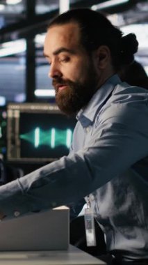 Yapay zeka tarafından değiştirildikten sonra iş yerinde kişisel eşyalarını toplayan dikey video üzgün veri merkezi çalışanı. Sunucu merkezi çalışma masasından eşyaları kaldıran programcı, yapay olarak kovuldu