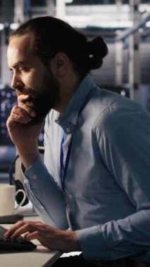 Yazılım güncellemeleri yaparken iş arkadaşıyla konuşan dikey video veri merkezi sistem yöneticisiName Sunucu odası bilişim uzmanı ve iş arkadaşı sohbet ediyor, altyapı geçişlerini optimize ediyor