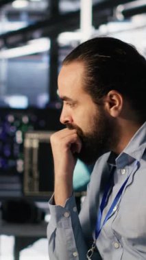 Veri merkezinde yapay zeka otomasyonunda işbirliği yapan dikey video sistemi yönetim ekibi. Sunucu çiftlik personeli makine öğrenme ayarlarını ayarlıyor, birlikte çalışıyorlar, kamera A