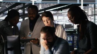 Sunucu merkezinde beyin fırtınası yapan yöneticiler, makine öğrenme kodlarını ve LLM görsel panellerini gözden geçiriyorlar. AI altyapı performansını izlemek için bilgisayar kullanan veri merkezi bilişim uzmanları, kamera A