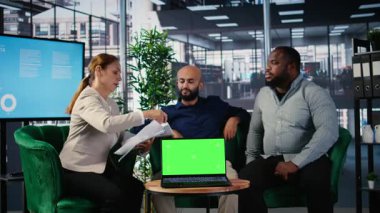 İş adamları, liderliği ve kurumsal başarıyı desteklemek için veri güdümlü içgörü ve kültürel çeşitliliği kullanarak, vizyonlarını dizüstü bilgisayarın yanında sergilemek üzere müzakere ediyorlar. Kamera A.