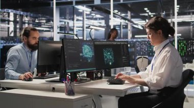 Başarılı yapay zeka konuşlanmasından sonra ofis sandalyelerinde heyecan içinde dans eden neşeli veri merkezi mühendisleri. Gülümseyen sunucu odası arkadaşları başarıyı kutluyor, performans hedeflerine ulaşıyorlar, kamera A