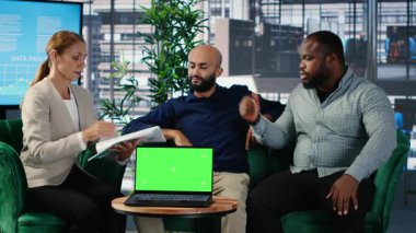 İş adamları, liderliği ve kurumsal başarıyı desteklemek için veri güdümlü içgörü ve kültürel çeşitliliği kullanarak, vizyonlarını dizüstü bilgisayarın yanında sergilemek üzere müzakere ediyorlar. Kamera B.