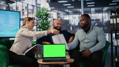 Şirket ortamında yeşil ekranın yanında araştırma yürüten CEO ve yürütme ekibi, şirket yatırımını ve performansını yönetmek için strateji geliştirme ve uzmanlık paylaşımı yapıyor. Kamera A.