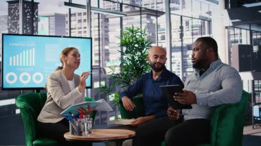 Bir iş toplantısındaki kurumsal liderlik ekibi küresel bir şirketteki idari kararları belirlemek ve yönlendirmek için veri odaklı analizleri ve stratejik düşünceleri kullanır. Kamera A.