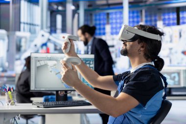 Photovoltaics fabrikası mühendisi VR gözlüklerini kullanarak montaj hattı yapılandırmalarını analiz ediyor ve değiştiriyor. Güneş panelleri sistem performans optimizasyonu için sanal gerçeklik donanımı kullanan bitki uzmanı