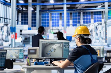 Yeşil enerji fotovoltaik fabrikası mühendisi güç üretimini maksimuma çıkarmak için bilgisayar parametrelerini ayarlıyor. Çevre dostu güneş paneli üretim tesisinde enerji arzını optimize eden teknisyen