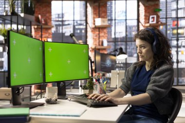 Bir ajansta izole edilmiş kopya alanı olan dijital medya profesyoneli çift monitörlü akıllı çalışma istasyonunu kullanıyor. Verimli çalışma alanı çoklu görev ve yapay zeka gelişimini destekler.