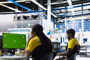 Güneş panelleri mühendisi, izole ekran bilgisayarıyla enerji tüketimini denetliyor. Photovoltaics tesis denetleyicisi monitör kullanarak fabrika kaynaklarının optimum kullanımını sağlıyor.