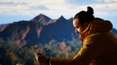 Düşüncesiz gezgin güvenlik önlemlerini göz ardı ediyor ve fotoğraf çekmeye çalışırken telefonunu düşürüyor. Yürüyüşçü, dikkatsiz ve dikkatsiz bir şekilde kendini tehlikeye atarken buldu. Kamera B.