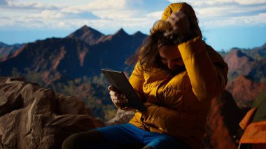 Gezgin vahşi doğada bağlı kalmaya çalışır ama zayıf sinyallerle, dağın tepesindeki tehlikeli rüzgarla mücadele eder. Yürüyüşçü çadırını rüzgarlı bir tepeye kuruyor. Kamera A.