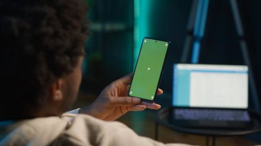 Mutlu genç adam evinde izole edilmiş fotokopi odasını kullanıyor, modern oturma odasında, neon ışıkları ve son moda mobilyalarla süslenmiş olarak dinleniyor. Aletleri olan bir erkek. Kamera A.