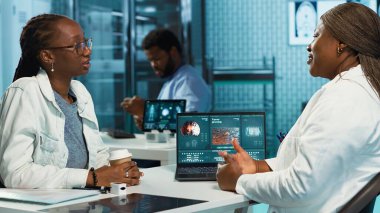 Akciğer enfeksiyonu olan genç bir kız doktor tavsiyesi istiyor, öksürük ve nefes almada yardımcı olması için tıbbı tartışıyor. Afrikalı Amerikalı hasta ve doktor klinikte. Kamera A.