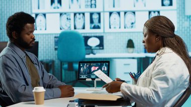 Radyoloji taramaları ve raporları kullanan bir kadın doktor, teşhis ve tedaviye odaklanırken hastalara tavsiye veriyor. Tıbbi uzman danışmanı olan Afrikalı Amerikalı doktor sıradan bir adam. Kamera A.