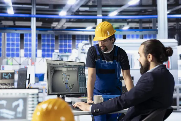 Güneş paneli ekip lideri, mühendis robotik makine ayarlarını nasıl ayarlayacağını gösteriyor. Photovoltaics fabrika müdürü ofiste teknisyenle konuşuyor, vites performans sorunları teşhis ediliyor