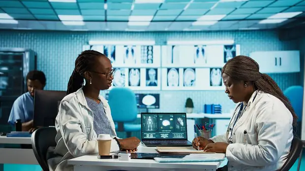 Genel pratisyen doktor sigorta kağıdına antibiyotik ve vitamin yazıp ağrı kesici ve ilaç listesi için doğru dozajı öneriyor. Tıbbi reçete. Kamera B.