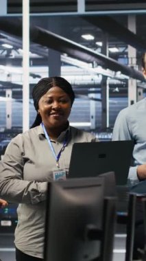 Dikey video Happy veri merkezi mühendislik ekibi üyeleri sinirsel ağ yazılım geliştirme konusunda işbirliği yapıyor. Gülümseyen sunucu merkezi iş yerinde makine öğrenme teknolojisi uygulayan iş arkadaşları