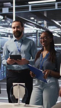 Dikey video Happy veri merkezi mühendislik ekibi üyeleri sinirsel ağ yazılım geliştirme konusunda işbirliği yapıyor. Gülümseyen sunucu merkezi iş yerinde makine öğrenme teknolojisi uygulayan iş arkadaşları