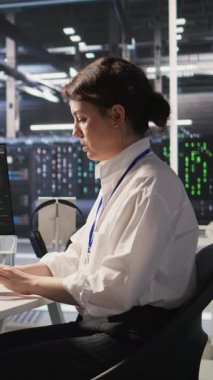 Başarılı yapay zeka konuşlanmasından sonra ofis koltuklarında heyecan içinde dans eden dikey video veri merkezi mühendisleri. Gülümseyen sunucu odası arkadaşları başarıyı kutluyor, performans hedeflerine ulaşıyorlar