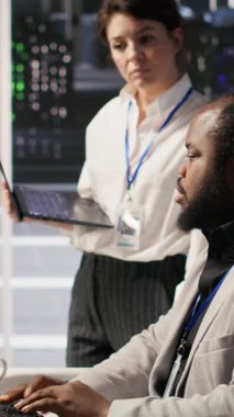 Dikey video Happy veri merkezi yöneticisi bilgisayarda sinirsel ağlar geliştiren mühendis için olumlu geri bildirim sağlıyor. Sunucudaki yapay zeka uygulamasından memnun olan neşeli bir yönetici.