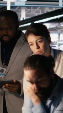 Sunucu merkezinde beyin fırtınası yapan dikey video yöneticileri, makine öğrenme kodlarını ve LLM görselleştirme panellerini gözden geçiriyorlar. Yapay zeka altyapısını izlemek için bilgisayar kullanan veri merkezi bilişim uzmanları