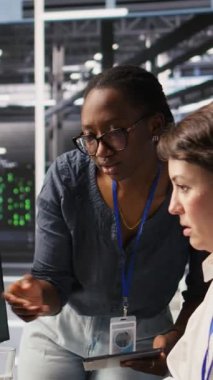 Yapay zeka araçlarını başarılı bir şekilde yerleştirdikten sonra veri merkezinde yumruk tokuşturan gülen teknisyenler. Sunucu odası mühendisliği ekibi makine öğrenme sistemi entegrasyonunun tamamlanışını kutladı