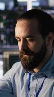 Veri merkezindeki dikey video mühendisi iş akışını düzene sokmak ve verimliliği artırmak için çalışma istasyonundaki masa ögelerini yeniden düzenliyor. Görevler sırasında verimliliği optimize etmek için masadaki nesneleri düzenleyen teknisyen