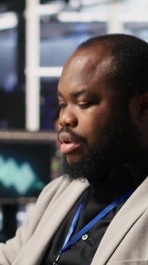 Dikey video tatmin edilmiş veri merkezi çalışanı süper bilgisayarlardaki sistem bakımını tamamlıyor. Gülümseyen teknisyen sunucuyu denetlerken yapay zeka modeli eğitim sonuçlarından memnun