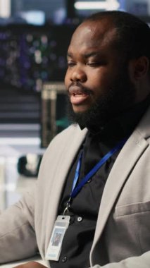 Süper bilgisayar sistemi bakımını bitirdikten sonra sevinçten dans eden dikey video veri merkezi çalışanı. Başarılı yapay zeka modeli eğitim sonuçlarından çok memnun olan mutlu mühendis sunucuyu denetliyor.