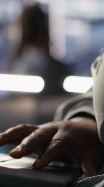 Veri merkezi mühendisinin dikey videosu AI LLM görüntülemesini izlemek için dizüstü bilgisayar kullanıyor. Sunuculara güç veren makine öğrenme süreçlerini denetlemek için dizüstü bilgisayar kullanan işçiler, kamera A