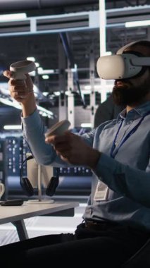 VR kulaklık kullanan dikey video veri merkezi teknisyeni AI LLM görselleştirmesini izliyor. Sunucu odası çalışanı sanal gerçeklik teknolojisini kulelerin güç makineleri öğrenme süreçlerini denetlemek için kullanıyor