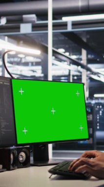 Dikey Veri Merkezi teknisyeni yeşil ekran model bilgisayar kullanarak yazılım güncellemeleri yapıyor. Sunucu odası bilişim uzmanı, altyapıyı krom anahtar izole ekran PC, kamera A kullanarak optimize ediyor.