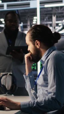 Veri merkezinde yapay zeka otomasyonunda işbirliği yapan dikey video sistemi yönetim ekibi. Sunucu çiftlik personeli makine öğrenme ayarlarını ayarlıyor, birlikte çalışıyorlar, kamera A