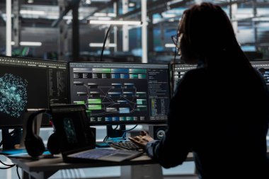 Veri merkezi yazılım geliştiricisi yapay zeka görselleştirme gösterge paneline bakarak ekipman performans sorunlarını belirliyor. Sunucu tarım uzmanı bilgisayardaki düğüm ağacına ve veri analiz grafiğine bakıyor