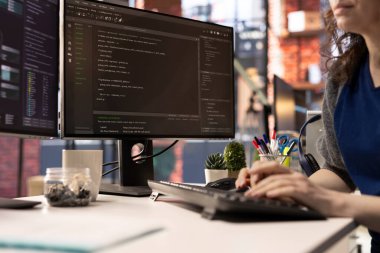 Ofisteki teknisyen UI 'ye bilgisayar monitöründe bakıyor ve programlama kodunu çalıştırıyor. Modern apartmanda kod yazmak ve test etmek için kodlama uygulaması kullanan bilişim serbest çalışanı.