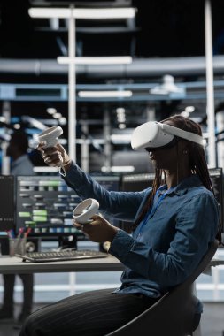 Sunucu odası teknisyeni, sanal gerçeklik teknolojisi ve yapay zekayı devre dışı bırakmak için kullanıyor. VR simülasyon kulaklığı kullanarak veri merkezi için AI güdümlü çözümler tasarla ve uygula