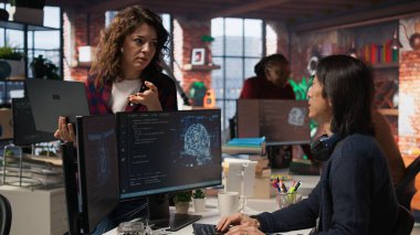 Dizüstü bilgisayar tutan stajyer kıdemli teknisyen gelişmiş yapay zeka algoritmasına sorular soruyor. Personel, Silikon Vadisi 'nin işyeri, kamera A' daki CTO müdüründen yardım istiyor.