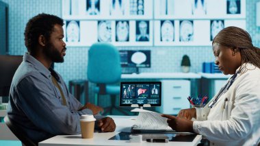 Afrika kökenli Amerikalı doktor ve hasta teşhis araçları, profesyonel bakım ve sağlıkla detaylı bir istişare içindeler. Doktor, genç bir adama hastalığın önlenmesi için tavsiyelerde bulunuyor. Kamera A.