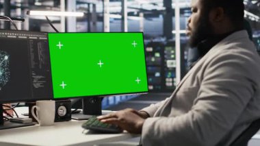Yeşil ekran masaüstü bilgisayarı üzerinde çalışan veri merkezi programcısı, depolama altyapısını güncelliyor. Bilgi işlem uzmanı sunucu merkezindeki bilgisayar modellemesini kullanıyor. Ağ teknolojisi ve kamera A ile dolu.